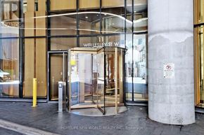 Toronto (Bay Street Corridor) condo for rent - The entrance to a building with a glass door and a sign that reads "Wellesley St."