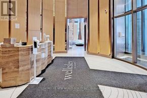 Toronto (Bay Street Corridor) condo for rent - A well-lit hallway with a carpet that reads "WellCler" and a sign that says "HOME IF, NEW OR WORLD REALTY INC."