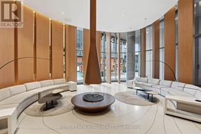 Toronto (Bay Street Corridor) condo for rent - A modern living room with a circular fireplace and a curved sofa.
