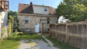 Sarnia apartment for rent - A stone house with a white door and a wooden fence.