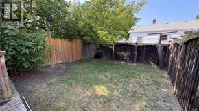 Sarnia apartment for rent - A backyard with a wooden fence and a tree.