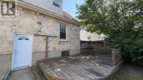 Sarnia apartment for rent - A stone building with a blue door and a wooden deck.