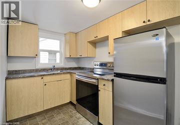 Cambridge apartment for rent - A kitchen with wooden cabinets and a stainless steel refrigerator.
