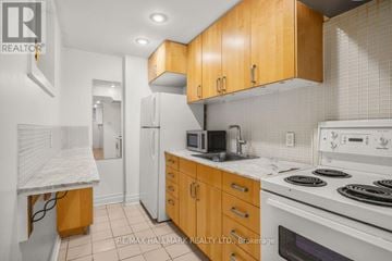Toronto (High Park-Swansea) multi-family for rent - A kitchen with wooden cabinets and white appliances.
