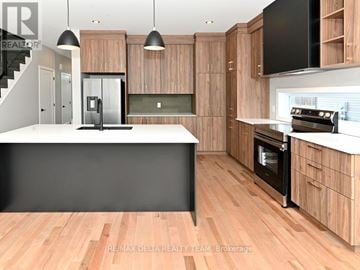 Alfred And Plantagenet apartment for rent - A modern kitchen with wooden cabinets and a black countertop.