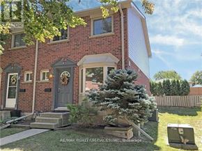 Brantford townhouse for rent - A red brick house with a grey door and a wreath on it.