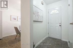 Brantford townhouse for rent - A hallway with a chair and a painting on the wall.