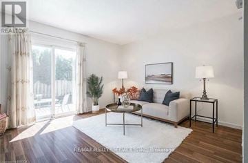 Brantford townhouse for rent - A living room with a white couch, a coffee table, and a painting on the wall.