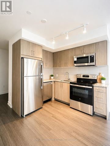 Toronto (Humber Heights) condo for rent - A modern kitchen with wooden cabinets and stainless steel appliances.