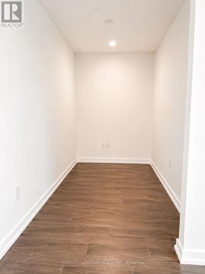 Toronto (Humber Heights) condo for rent - A long, empty hallway with wooden floors and white walls.