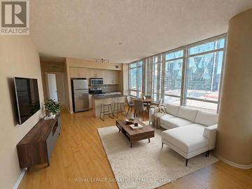 Toronto (Waterfront Communities) condo for rent - A living room with a white couch and a wooden floor.
