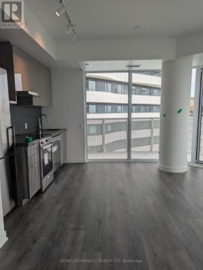 Vaughan (Steeles West Industrial) condo for rent - A kitchen with dark wood floors and a large window.