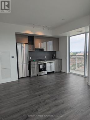 Vaughan (Steeles West Industrial) condo for rent - A modern kitchen with dark wood floors and a large window overlooking the city.