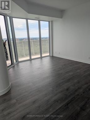 Vaughan (Steeles West Industrial) condo for rent - A room with a view of the city through large windows.