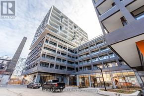 Toronto (Niagara) condo for rent - A modern multi-story building with a parking lot in front.