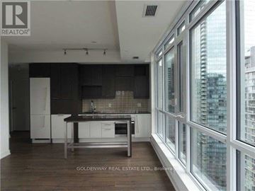 Toronto (Waterfront Communities) condo for rent - A kitchen with white cabinets and a large island with a sink.