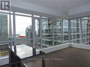 Toronto (Waterfront Communities) condo for rent - A room with a table and chairs in front of a large window with a view of the city.