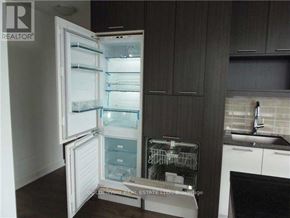 Toronto (Waterfront Communities) condo for rent - A refrigerator with its door open is in a kitchen.