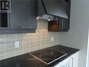 Toronto (Waterfront Communities) condo for rent - A kitchen with a black counter top and white cabinets.