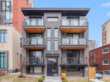 Ottawa multi-family for rent - A modern multi-story building with balconies and a black door.