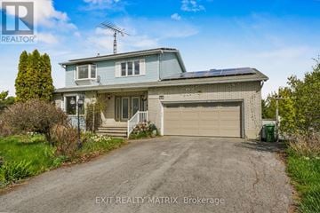 Russell apartment for rent - A house with a garage and a driveway in front of it.