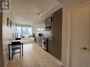 Toronto (Waterfront Communities) condo for rent - A modern kitchen with a dining table and chairs.