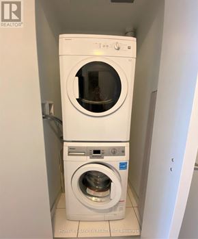 Toronto (Waterfront Communities) condo for rent - A white front loading washing machine with a smaller dryer unit underneath it.