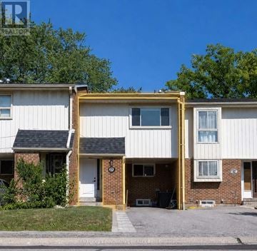 Toronto (L'amoreaux) townhouse for rent - A two-story house with a white exterior and a brick facade.