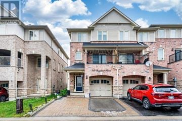 Ajax (Central East) townhouse for rent - A red car is parked in front of a two-story brick house.