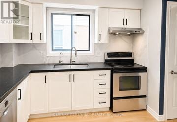 Oshawa (Vanier) apartment for rent - A kitchen with white cabinets and black countertops.