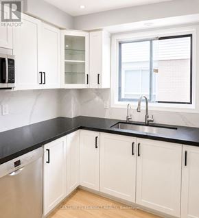 Oshawa (Vanier) apartment for rent - A kitchen with white cabinets and black countertops.