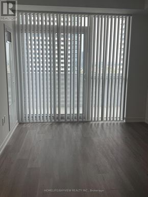 Vaughan (Vaughan Corporate Centre) condo for rent - A room with a sliding door and wooden floor.