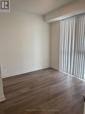 Vaughan (Vaughan Corporate Centre) condo for rent - A room with wooden flooring and a window with blinds.