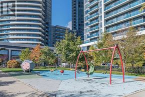 Markham (Grandview) condo for rent - A playground with a red swing set and a blue slide in the foreground with apartment buildings in the background.