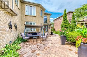 Mississauga (East Credit) apartment for rent - A patio with a table and chairs is surrounded by a brick wall and a variety of plants.