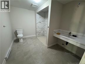 Hampton apartment for rent - A bathroom with a toilet, sink, and marble tile flooring.