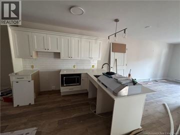 Hampton apartment for rent - A kitchen with white cabinets and a white island with a counter on it.