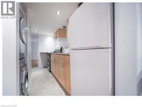 Waterloo apartment for rent - A kitchen with a white refrigerator, wooden cabinets, and a washing machine.