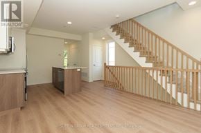 Mississauga (Applewood) townhouse for rent - A wood staircase with a white wall and a door in the background.