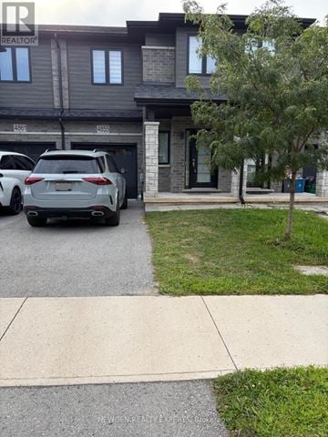 Niagara Falls (Morrison) townhouse for rent - A grey SUV is parked in front of a house with a realtor sign.