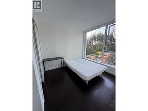 Vancouver apartment for rent - A bedroom with a large bed and a window overlooking a cityscape.