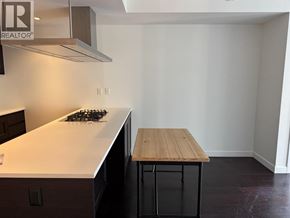 Vancouver apartment for rent - A kitchen with a wooden table and a stove top.