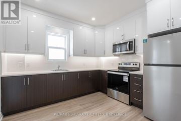 St. Catharines (E. Chester) apartment for rent - A kitchen with white cabinets and a stainless steel refrigerator.