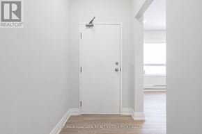 St. Catharines (E. Chester) apartment for rent - A white door in a room with a brokerage logo on the wall.