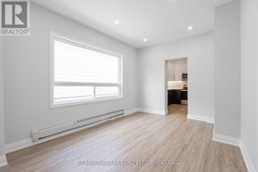 St. Catharines (E. Chester) apartment for rent - A spacious room with a window and a door leading to another room.