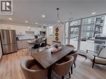 Kitchener condo for rent - A modern kitchen with a dining table and chairs.