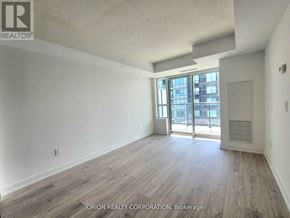 Pickering (Bay Ridges) condo for rent - A spacious room with wood flooring and a sliding glass door leading to a balcony.