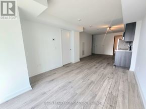 Pickering (Bay Ridges) condo for rent - A spacious room with wood flooring and white walls.