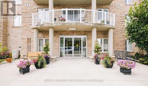 King (Schomberg) condo for rent - A building with a balcony and flower pots in front.