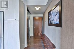 Toronto (Mimico) condo for rent - A hallway with a wooden bench and a painting on the wall.